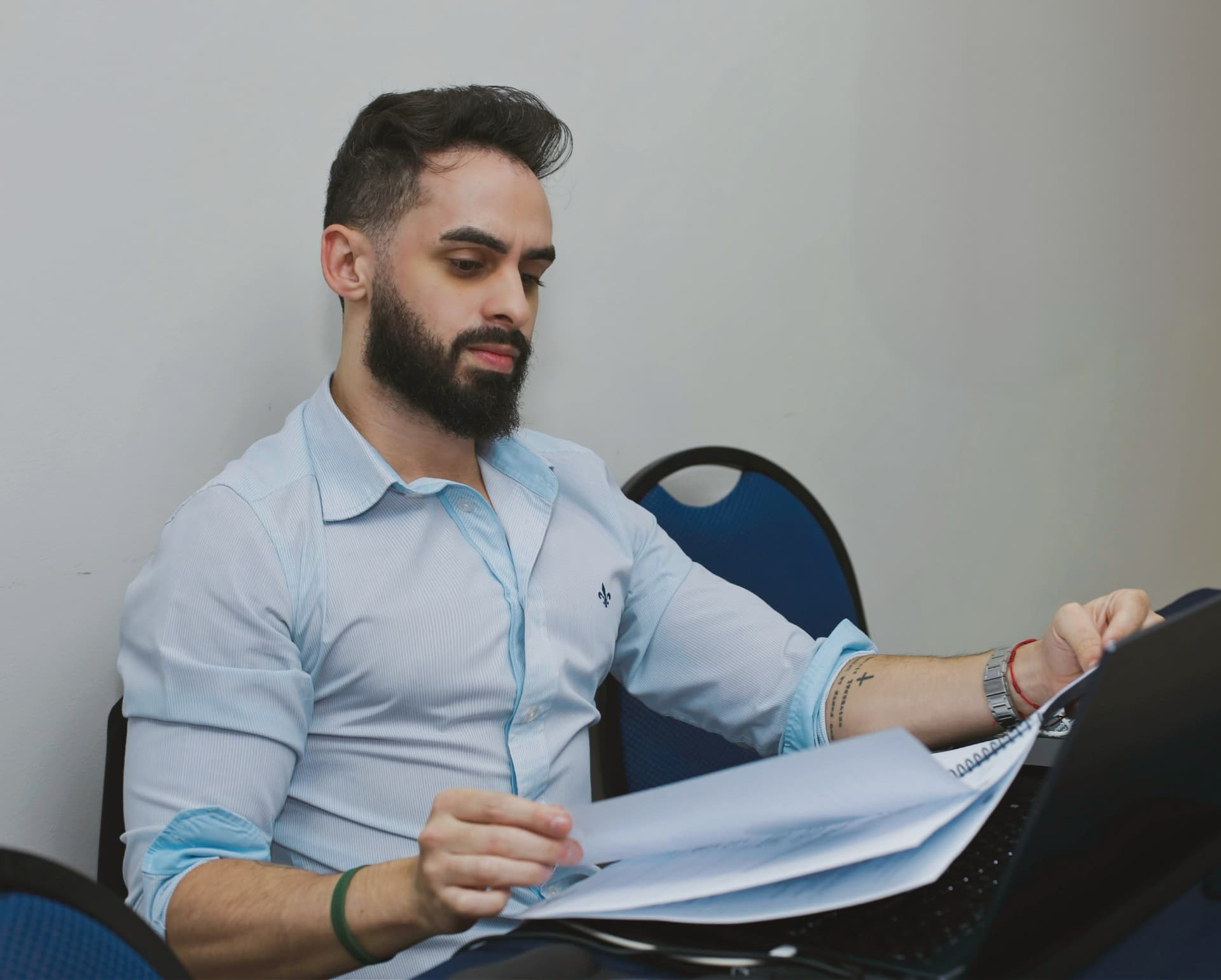 Iverson Alves analisando documentos e planilhas ao lado do notebook durante planejamento comercial.