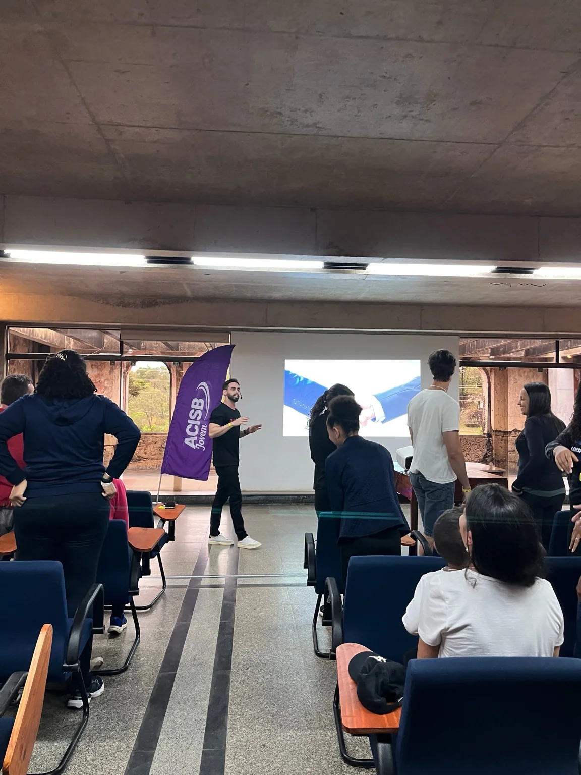 Iverson Alves conduzindo atividade de desenvolvimento com participantes de uma associação empresarial jovem.