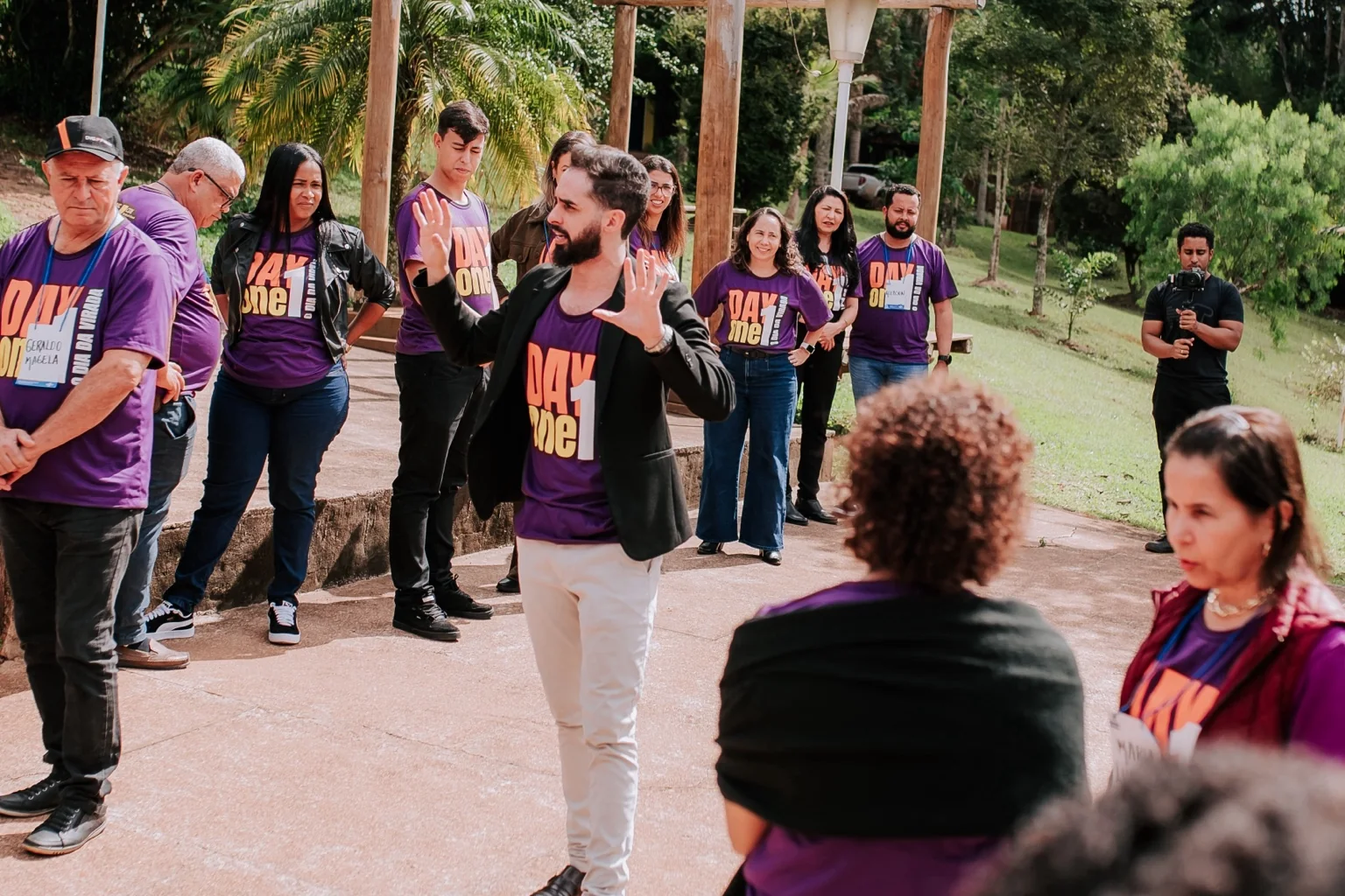 Iverson Alves conduzindo treinamento vivencial com profissionais em ambiente externo.